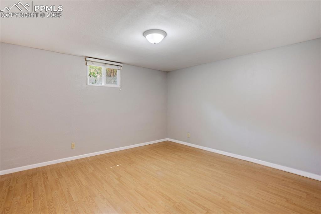 Image 19 of 35: Unfurnished room with light wood finished floors and a textured ceiling