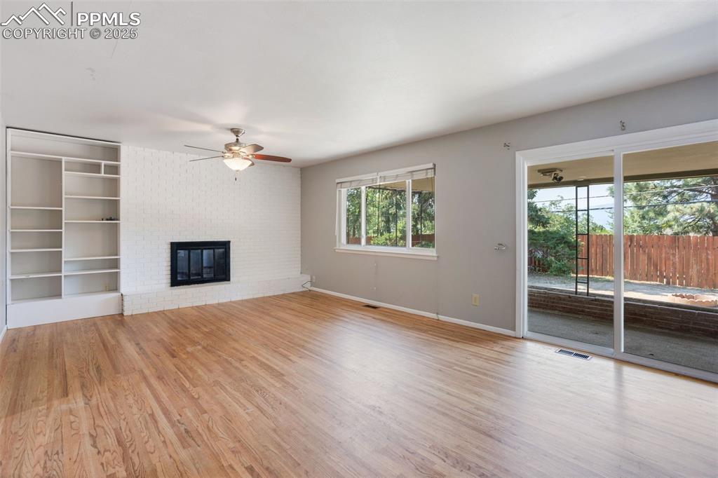 Image 4 of 35: Unfurnished living room featuring plenty of natural light, light wood finis