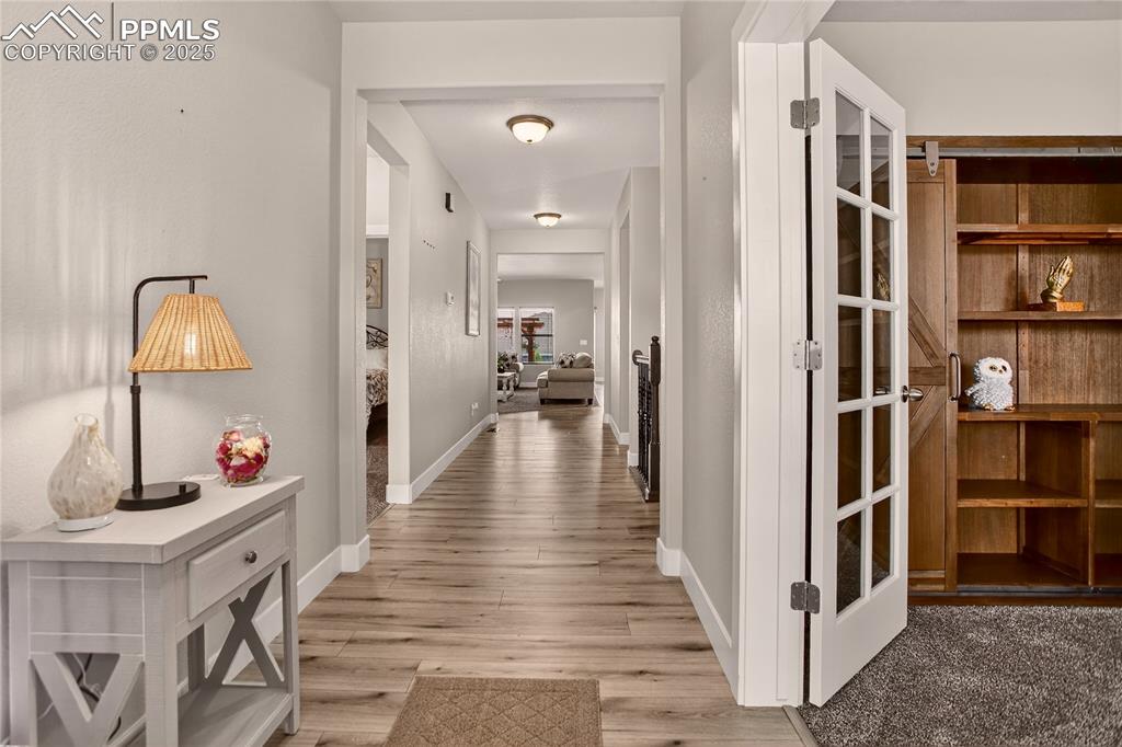 Image 3 of 38: Hallway featuring light wood finished floors and baseboards