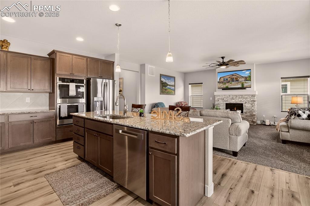 Image 7 of 38: Kitchen with pendant lighting, ceiling fan, stainless steel appliances, lig