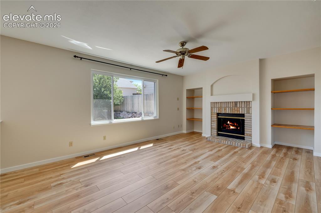 Image 12 of 47: Main level family room has new luxury vinyl plank flooring and gas fireplac