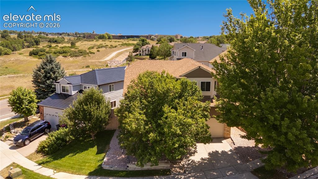 Image 3 of 47: Front aerial view with Rampart Open Space in background, walk to trails, di