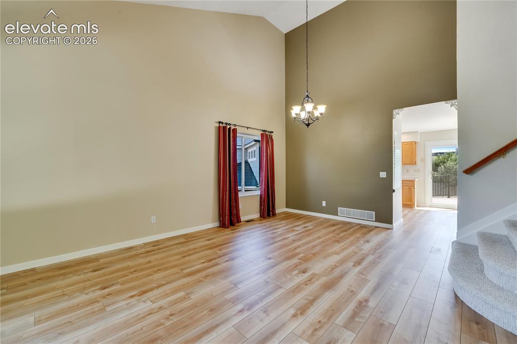 Image 8 of 47: Living room/dining room combo has vaulted ceiling