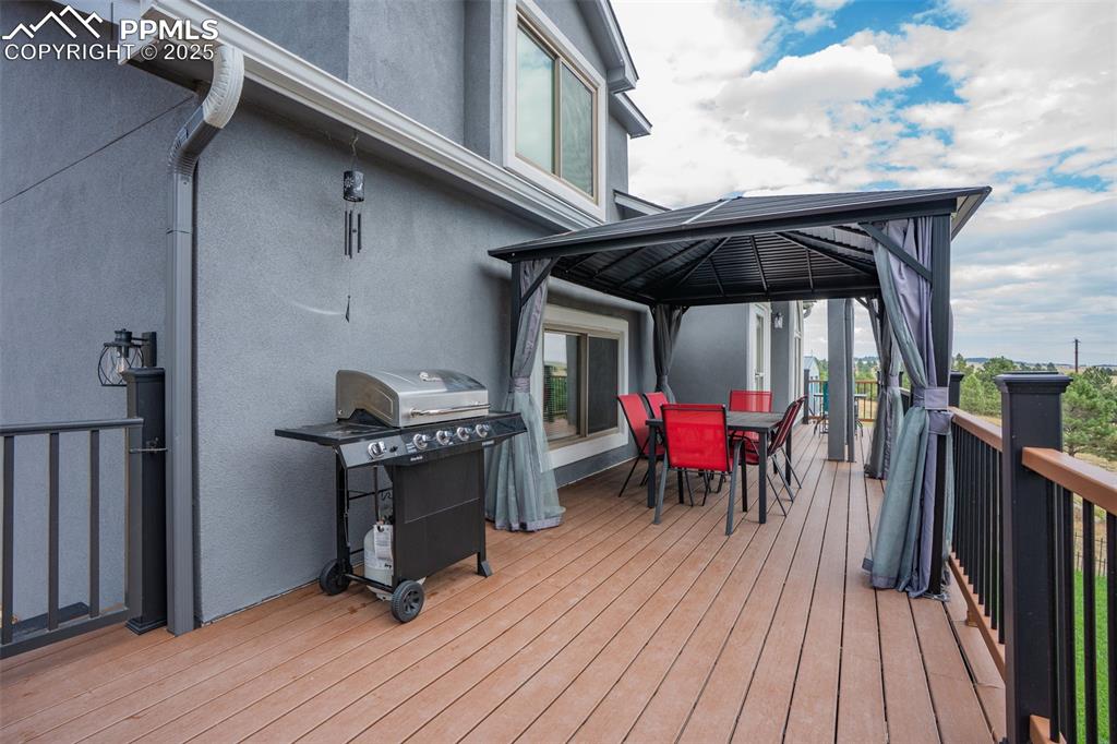 Image 15 of 47: Deck featuring outdoor dining space, a gazebo, and a grill