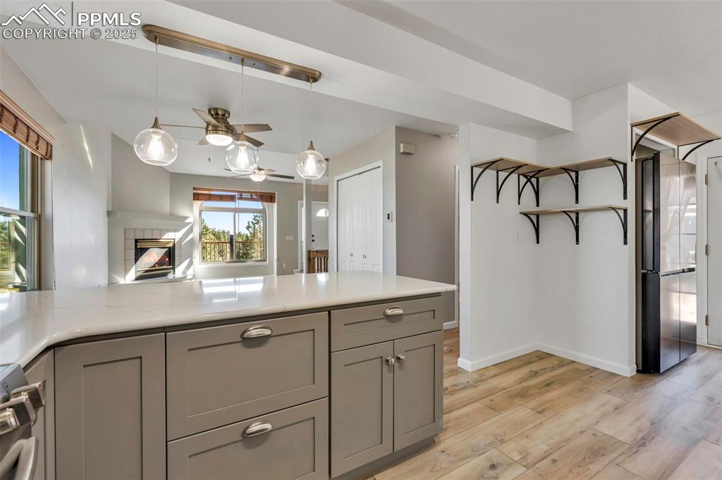 Image 23 of 47: Kitchen is all new with decorative light fixtures, white granite countertop