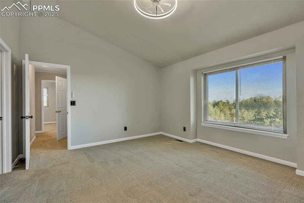 Image 27 of 47: Spare room with healthy amount of natural light, vaulted ceiling, and light