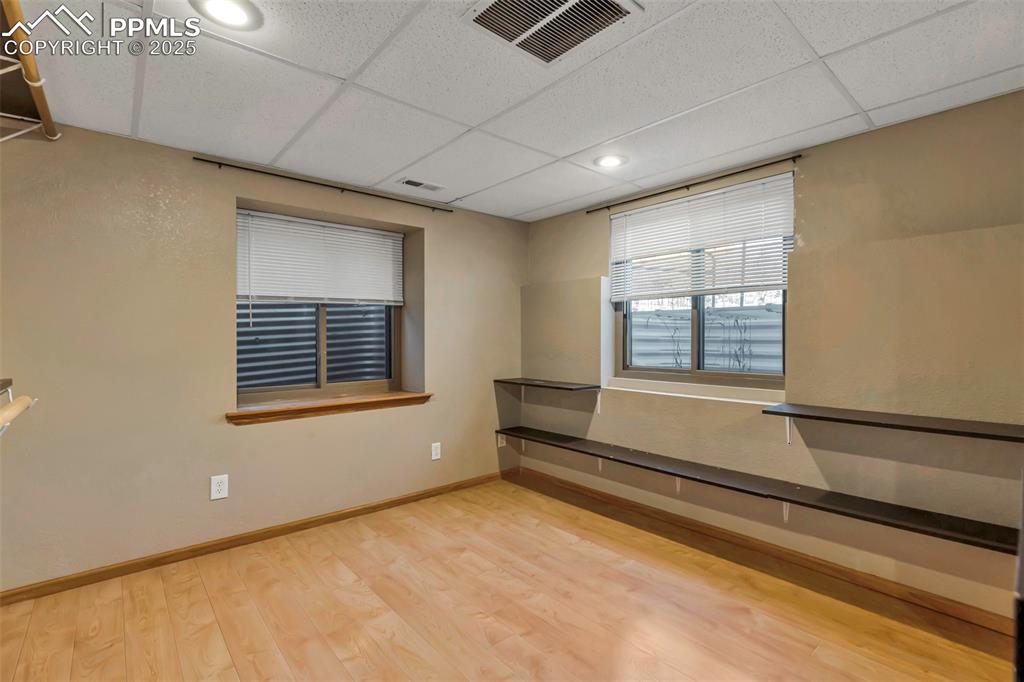 Image 39 of 47: Unfurnished room featuring light wood-type flooring and a drop ceiling