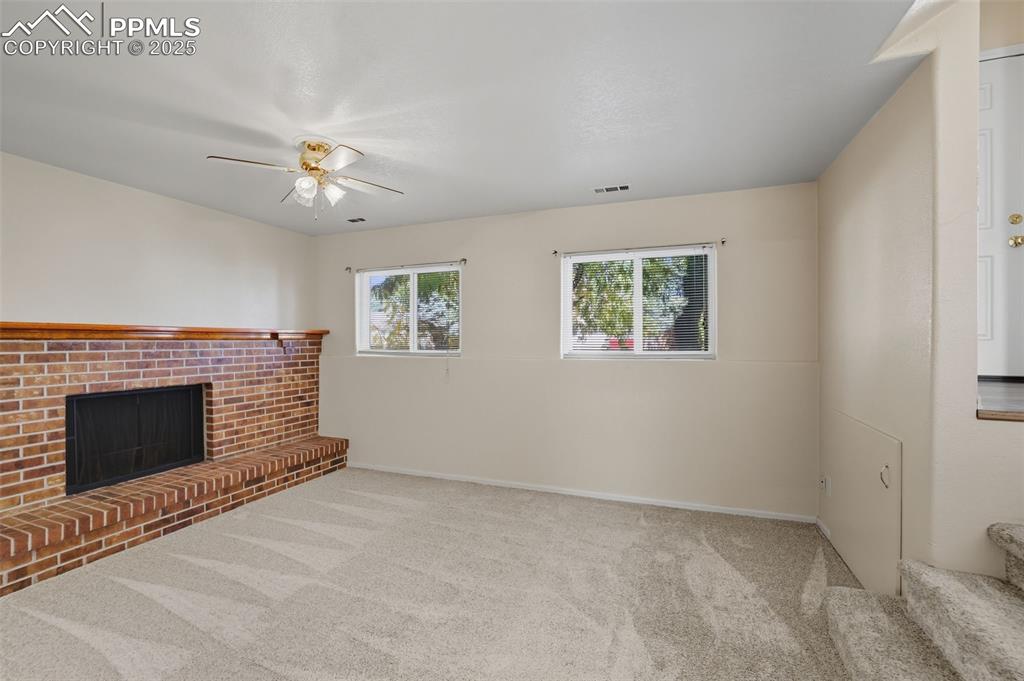 Image 22 of 45: lower level living room with fireplace