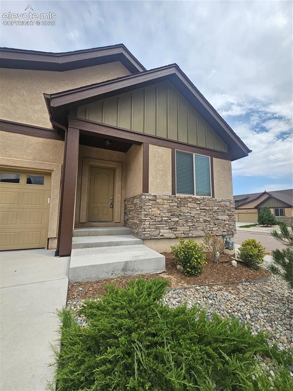 Image 2 of 32: Welcoming covered front enrty with a charming porch area,stone accents, and