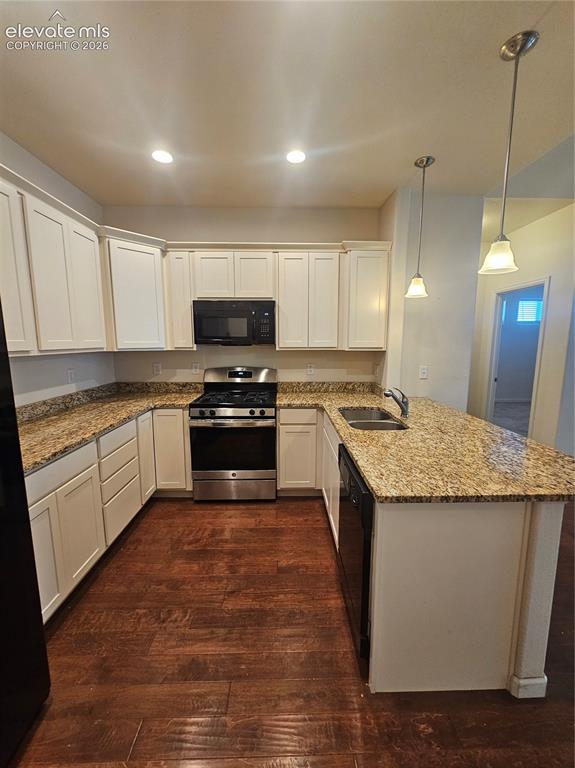 Image 4 of 32: Well- Appointed kitchen featuring a spacious center island with seating, am