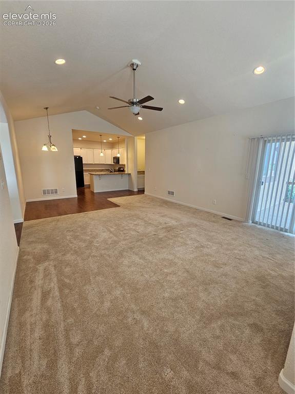 Image 5 of 32: Spacious living room with wall-to-wall carpet and a bright window offering