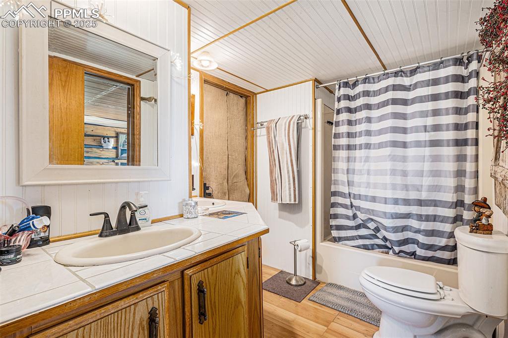 Image 12 of 25: Full bath featuring vanity, shower / bath combo with shower curtain, toilet