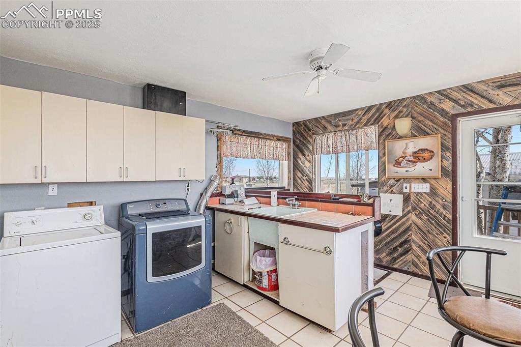 Image 15 of 25: Washroom with a sink, a healthy amount of sunlight, ceiling fan, and washin