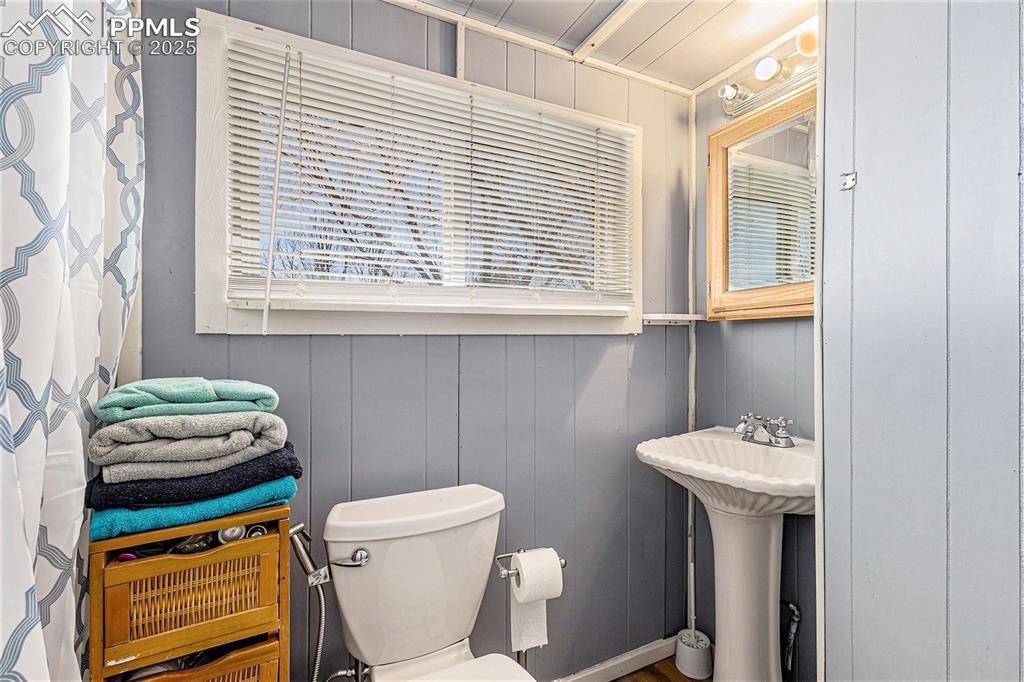 Image 8 of 25: Bathroom featuring a decorative wall and toilet