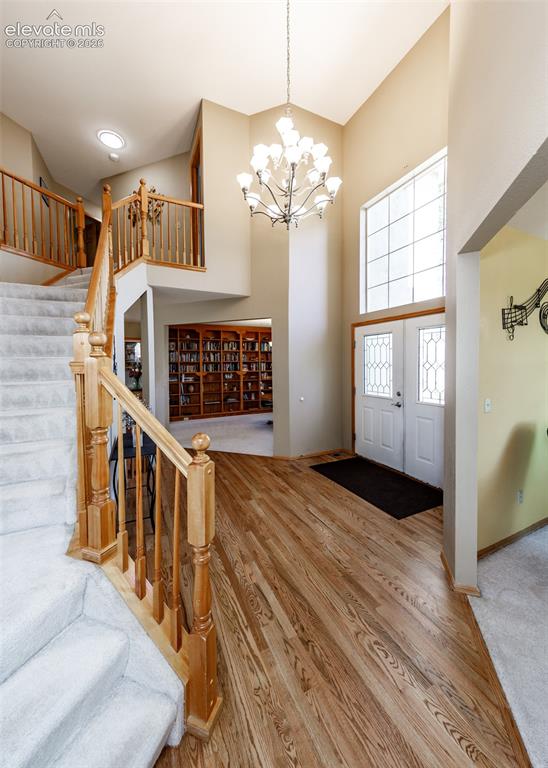 Image 10 of 48: Two-story foyer with vaulted ceiling, wood-finish flooring, staircase with 