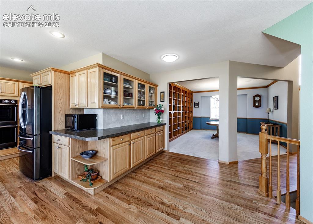 Image 13 of 48: Hardwood flooring, natural wood cabinetry, built-in double oven, recessed l