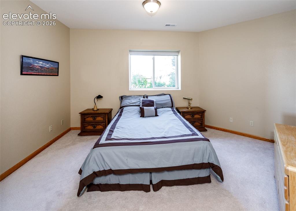 Image 36 of 48: Soft neutral wall tones, light-colored carpeting, and natural wood baseboar
