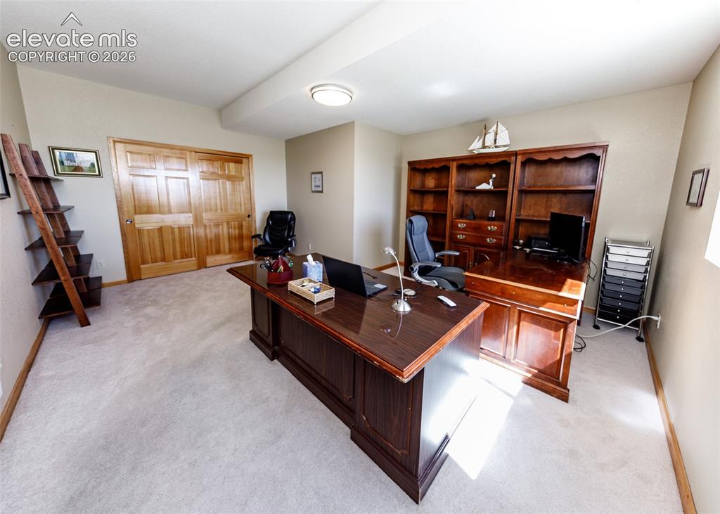 Image 38 of 48: Sophisticated home office featuring a commanding wood executive desk, exten