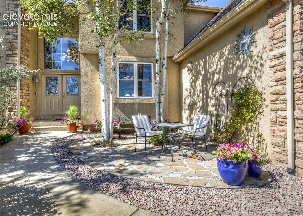 Image 6 of 48: Stucco exterior with stone accents, a double-door entry, and a flagstone pa
