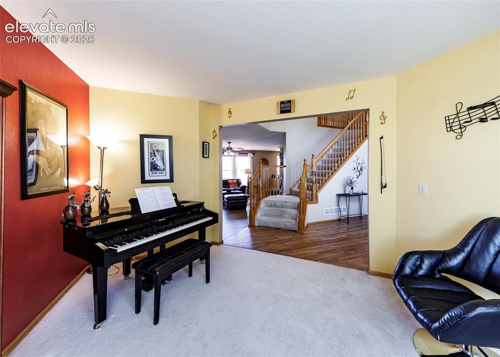 Image 9 of 48: Multi-level interior featuring wood-finish flooring, a carpeted staircase w