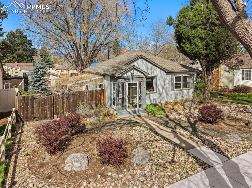 Image 2 of 28: Bungalow-style home featuring a shingled roof and a chimney