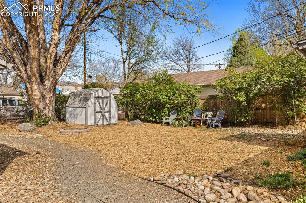 Image 26 of 28: Fenced yard featuring a storage unit