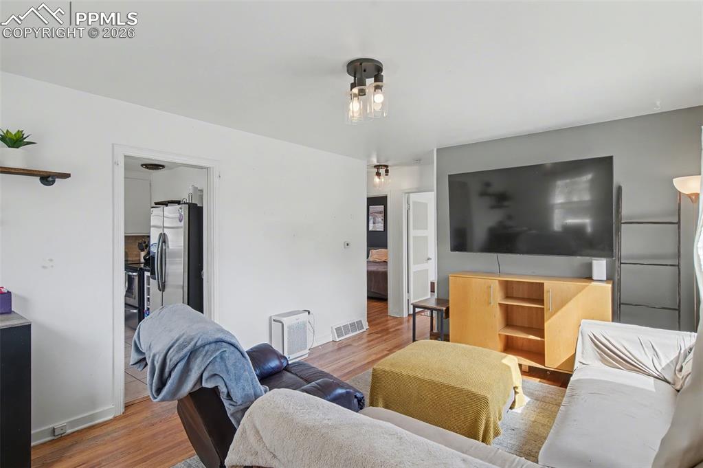 Image 7 of 28: Living room featuring wood finished floors and baseboards