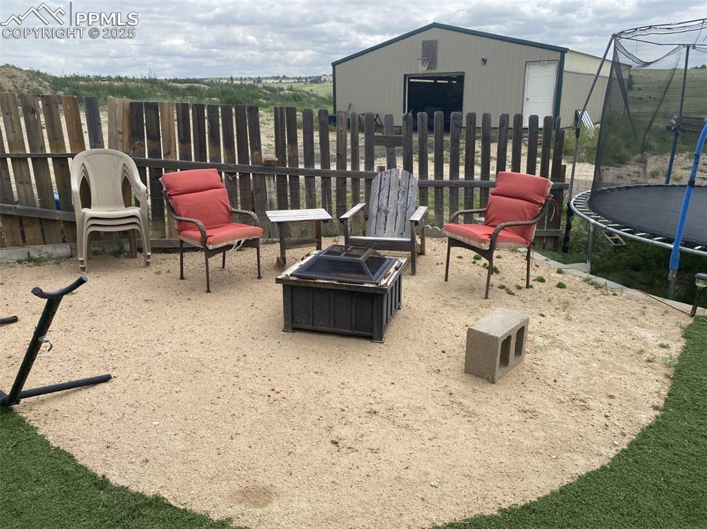 Image 31 of 48: Fire pit, and trampoline -your summer fun will be non-stop