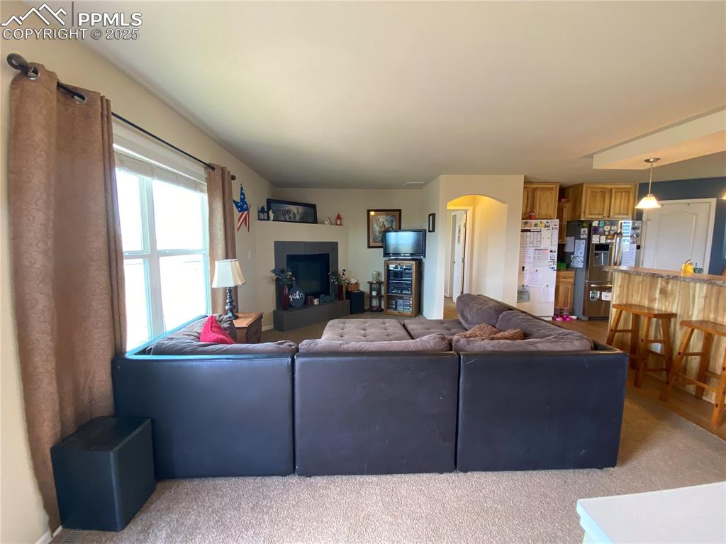 Image 6 of 48: The living room has windows that face Pikes Peak