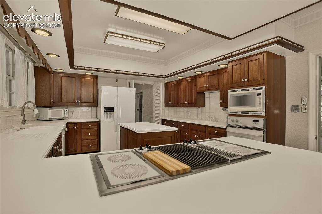 Image 18 of 49: Kitchen, and view of formal dining room.