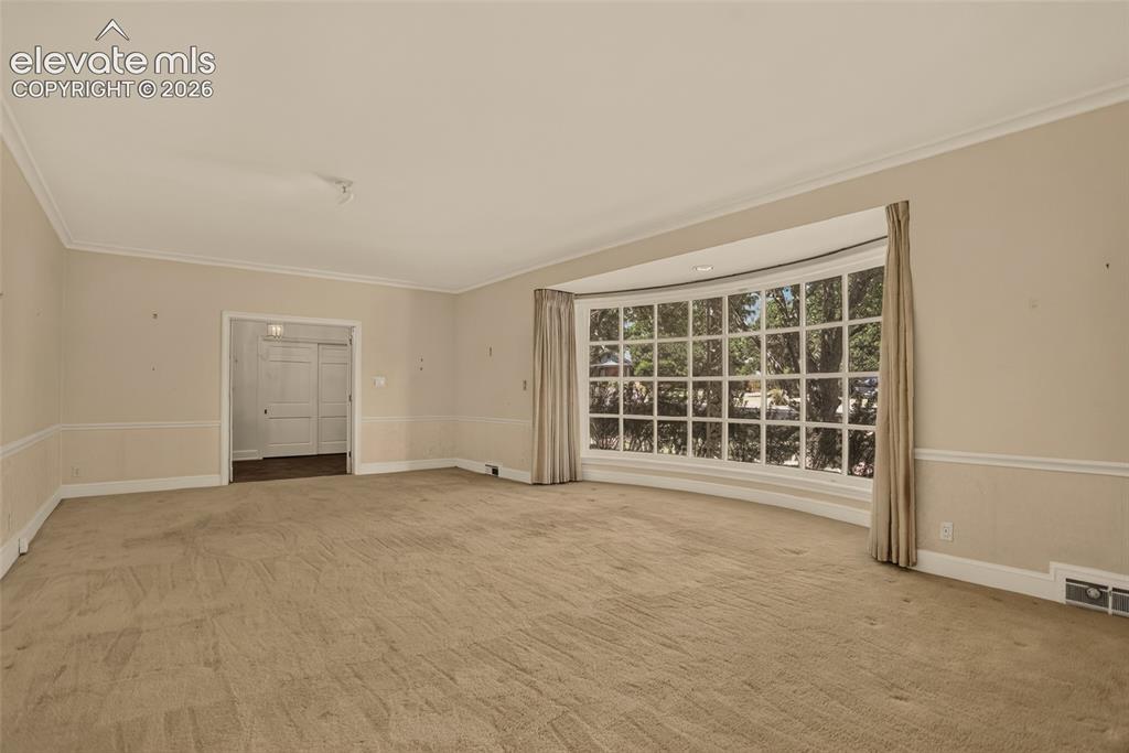 Image 9 of 49: Living room, with view into kitchen and foyer.