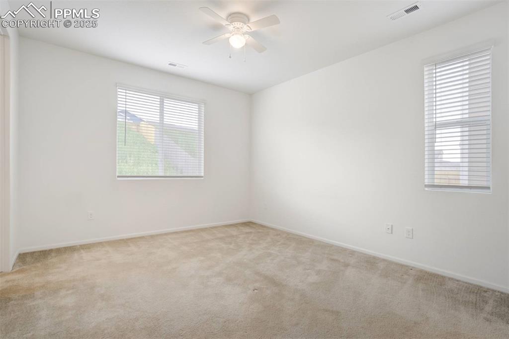Image 15 of 36: Spare room featuring light colored carpet and a ceiling fan