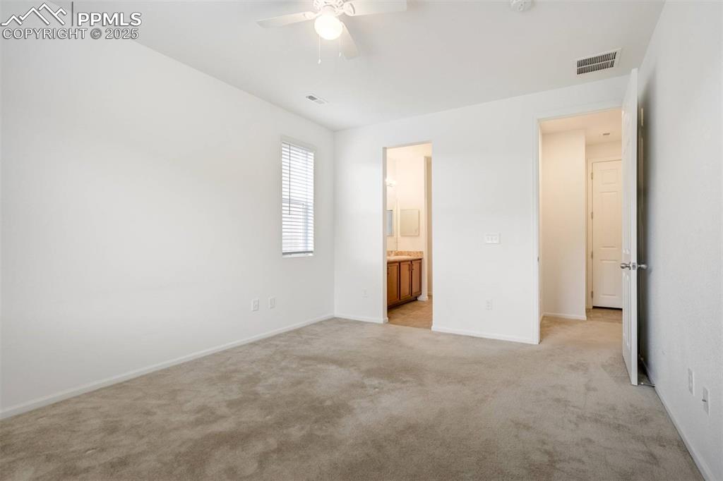 Image 18 of 36: Unfurnished bedroom featuring light colored carpet, ensuite bathroom, and a