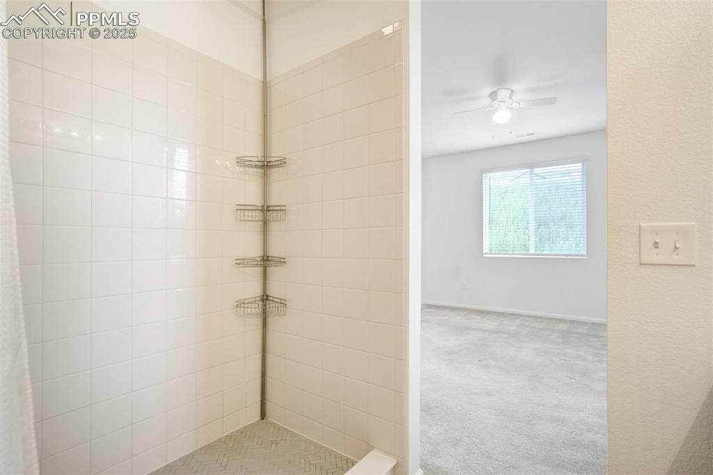 Image 22 of 36: Full bath featuring a tile shower and a ceiling fan