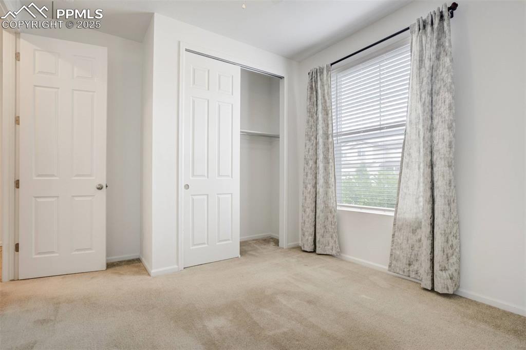 Image 25 of 36: Unfurnished bedroom with carpet and a closet