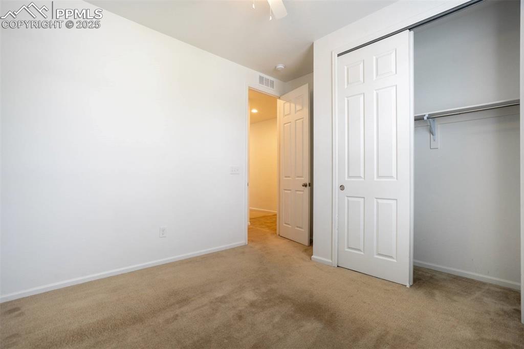 Image 26 of 36: Unfurnished bedroom featuring carpet flooring, a closet, and a ceiling fan