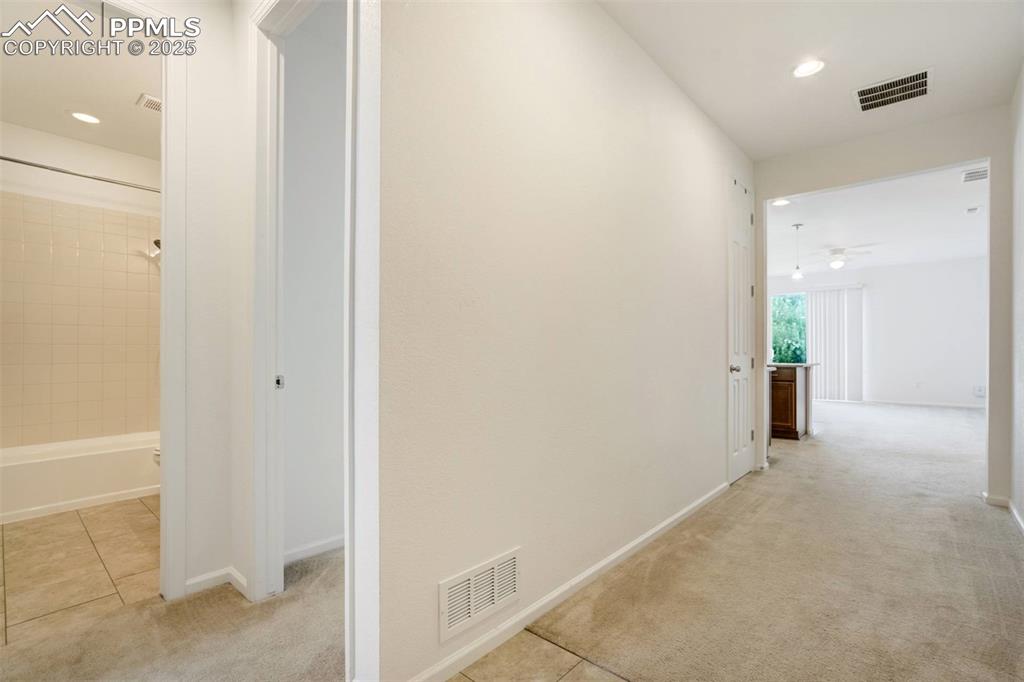 Image 32 of 36: Hall with light carpet, recessed lighting, and light tile patterned floors