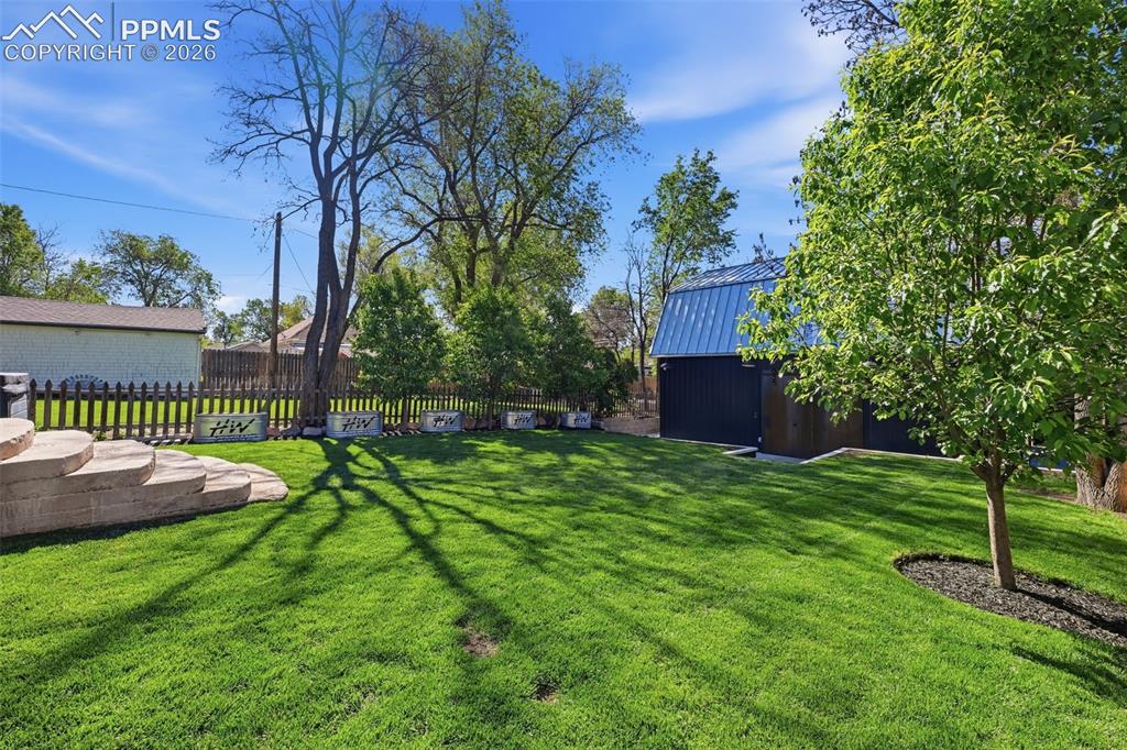 Image 28 of 50: The backyard has auto sprinklers and a dripline to the garden beds.