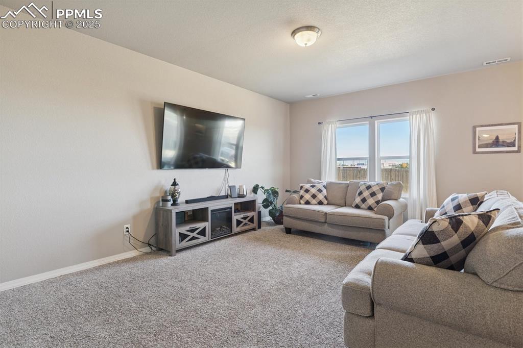 Image 15 of 45: Carpeted living room featuring baseboards