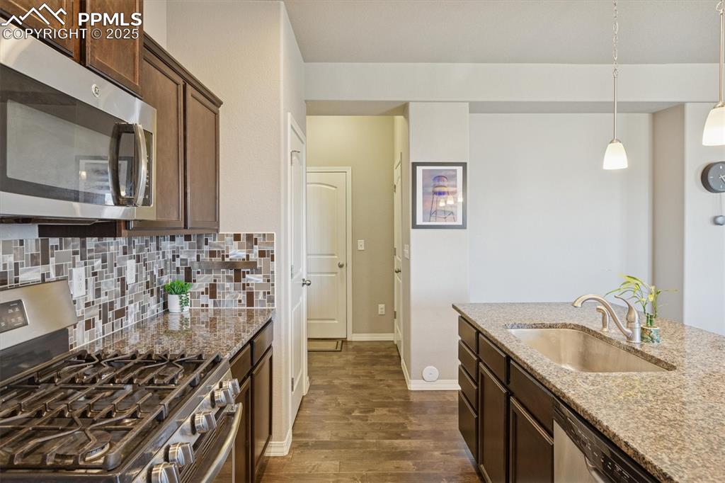 Image 23 of 45: Kitchen with appliances with stainless steel finishes, light stone countert