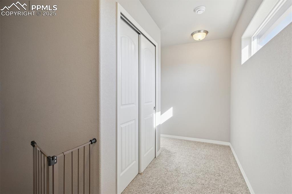 Image 34 of 45: Hall with light carpet and baseboards
