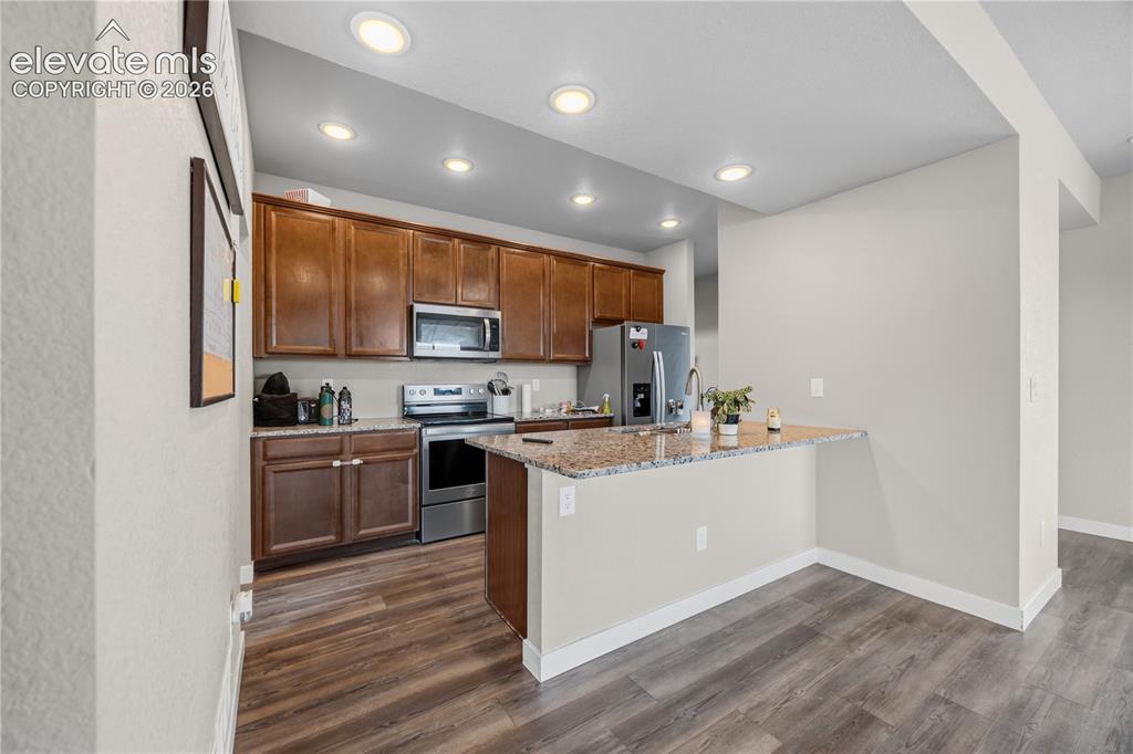Image 13 of 45: Stainless steel appliances include a range oven, microwave, dishwasher, and