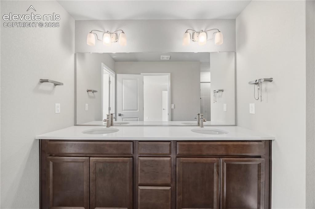 Image 21 of 45: Upper Level Primary Bathroom with a comfort height, dual sink vanity and mi