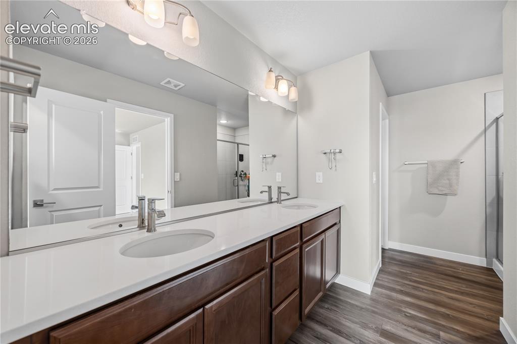 Image 22 of 45: The Primary Bathroom features an extended vanity with dual sinks, mirror, a