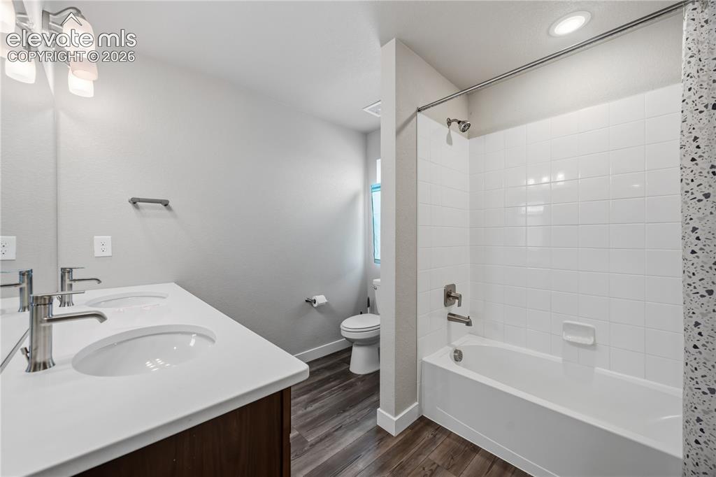 Image 30 of 45: Upper Level Full Bathroom with LVP flooring, dual sink vanity, mirror, and