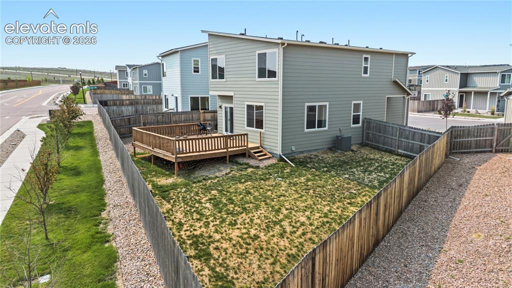 Image 37 of 45: Rear view of home and fenced backyard.