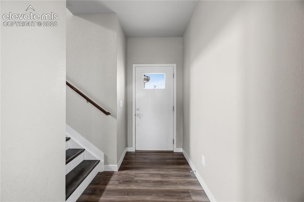 Image 5 of 45: Front Entry with wood stairs to the upper level.
