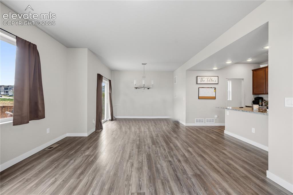 Image 8 of 45: The spacious Living Room flows into the Dining Area and has lots of windows