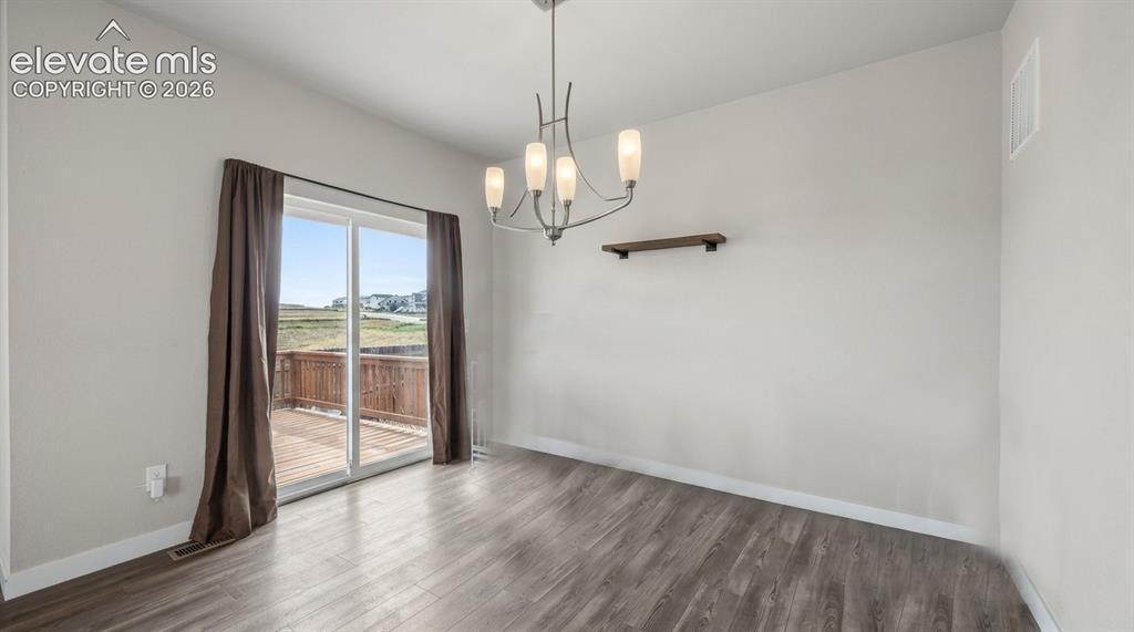 Image 9 of 45: The Dining Area has a modern light fixture and slider out to an expansive b