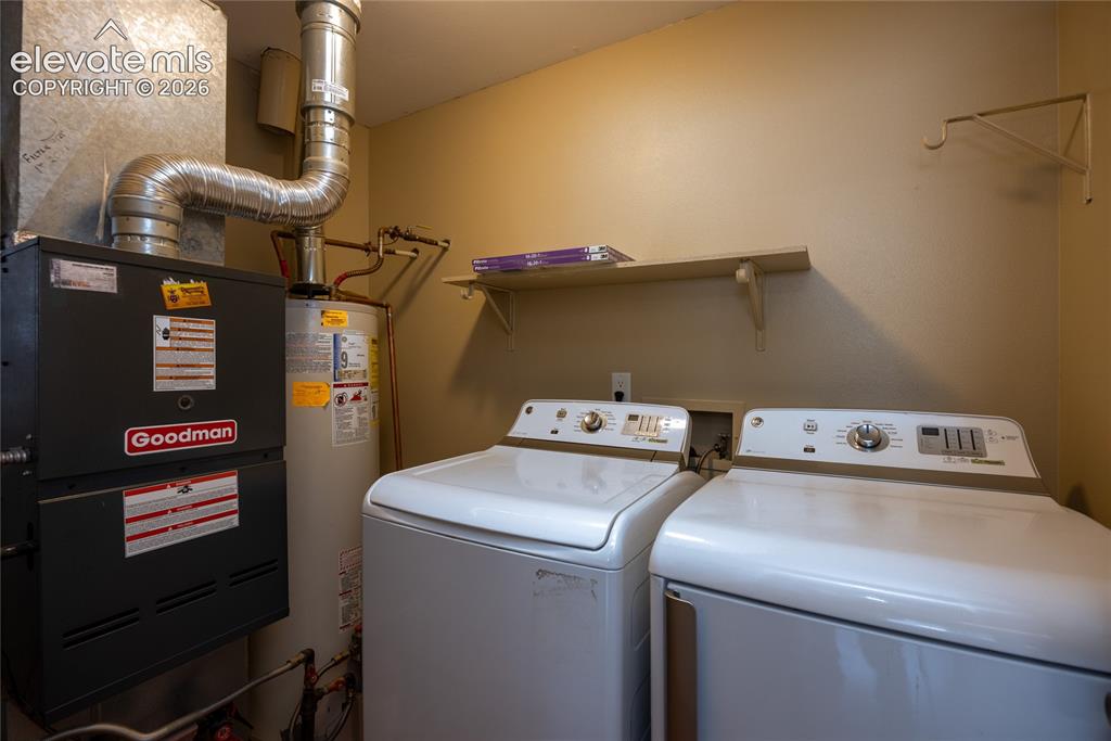 Image 15 of 26: Utility area with water heater, furnace, and wall-mounted shelving